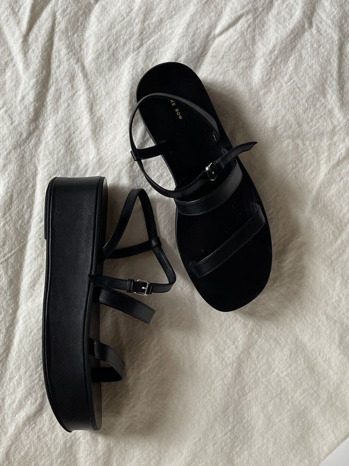 Crafting Captivating Headlines: Your awesome post title goes here Elegant black strappy platform sandals on textured white fabric background.
