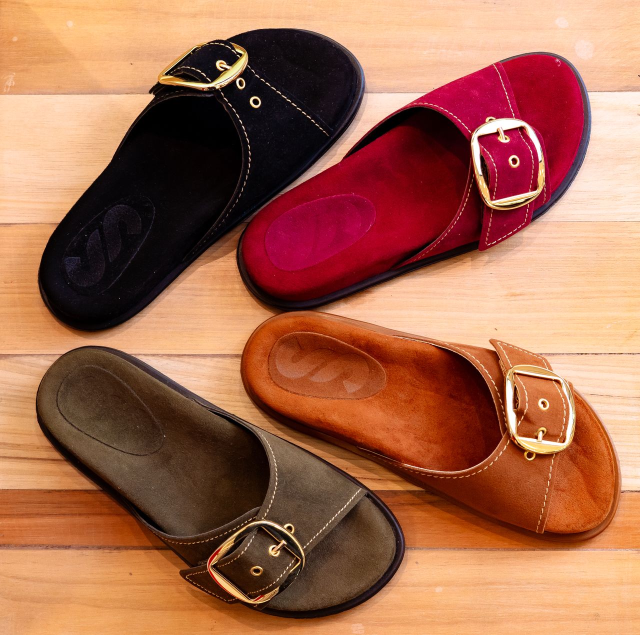 Mastering the First Impression: Your intriguing post title goes here A variety of stylish leather buckle sandals arranged on a wooden floor.